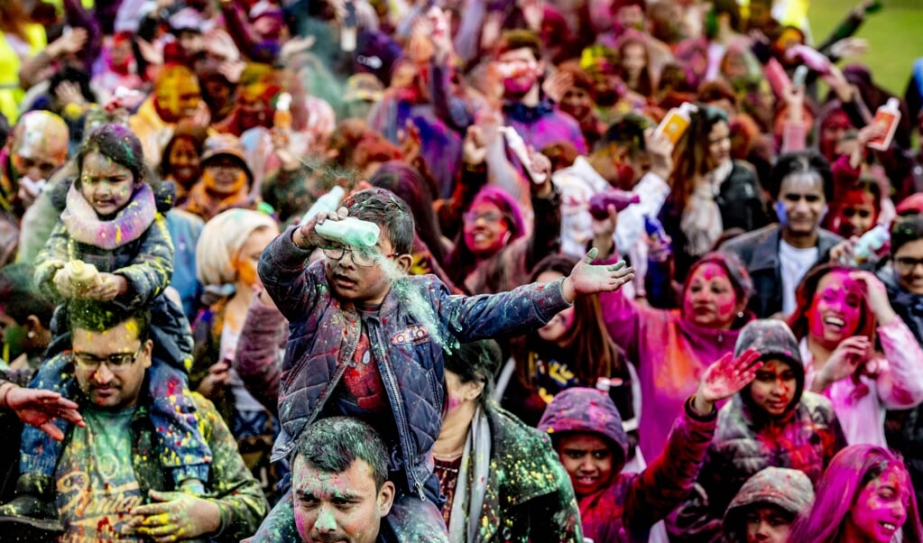 Hindoestanen besprenkelen elkaar met kleurrijk poeder tijdens de viering van het Holifeest in Den Haag. 'In de bundel blijkt dat zij zich niet gekend en erkend voelen binnen de geestelijke gezondheidszorg.' (beeld anp / Robin Utrecht)