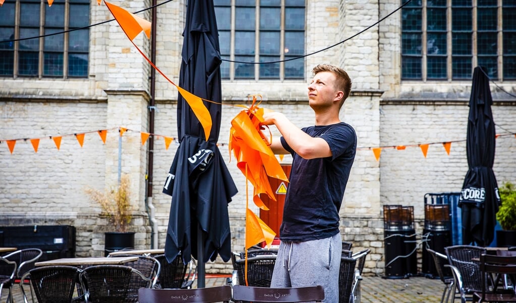 Een caféhouder in de binnenstad van Breda ruimt de EK-versiering op. (beeld hollandse hoogte / Jeffrey Groeneweg)