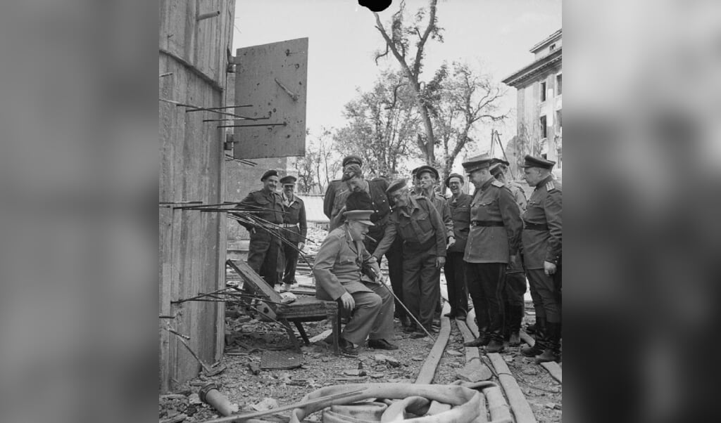 Winston Churchill zit op een tuinstoel bij de Führerbunker. (beeld Imperial War Museums (IWM) Londen / wikimedia)