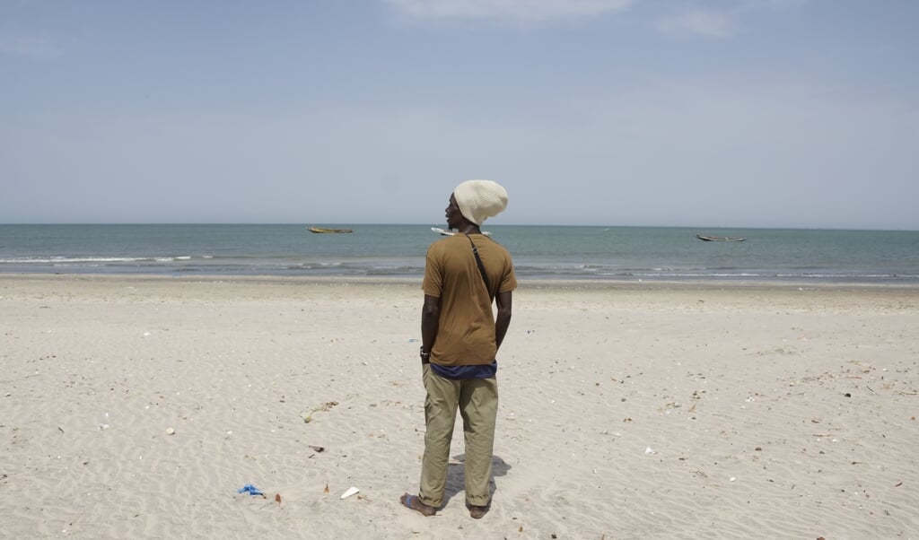 Een potentiële migrant op het strand van Bakau in Gambia. Vanaf de Gambiaanse kust is het hemelsbreed 1700 kilometer naar Gran Canaria. (beeld Lex Rietman)