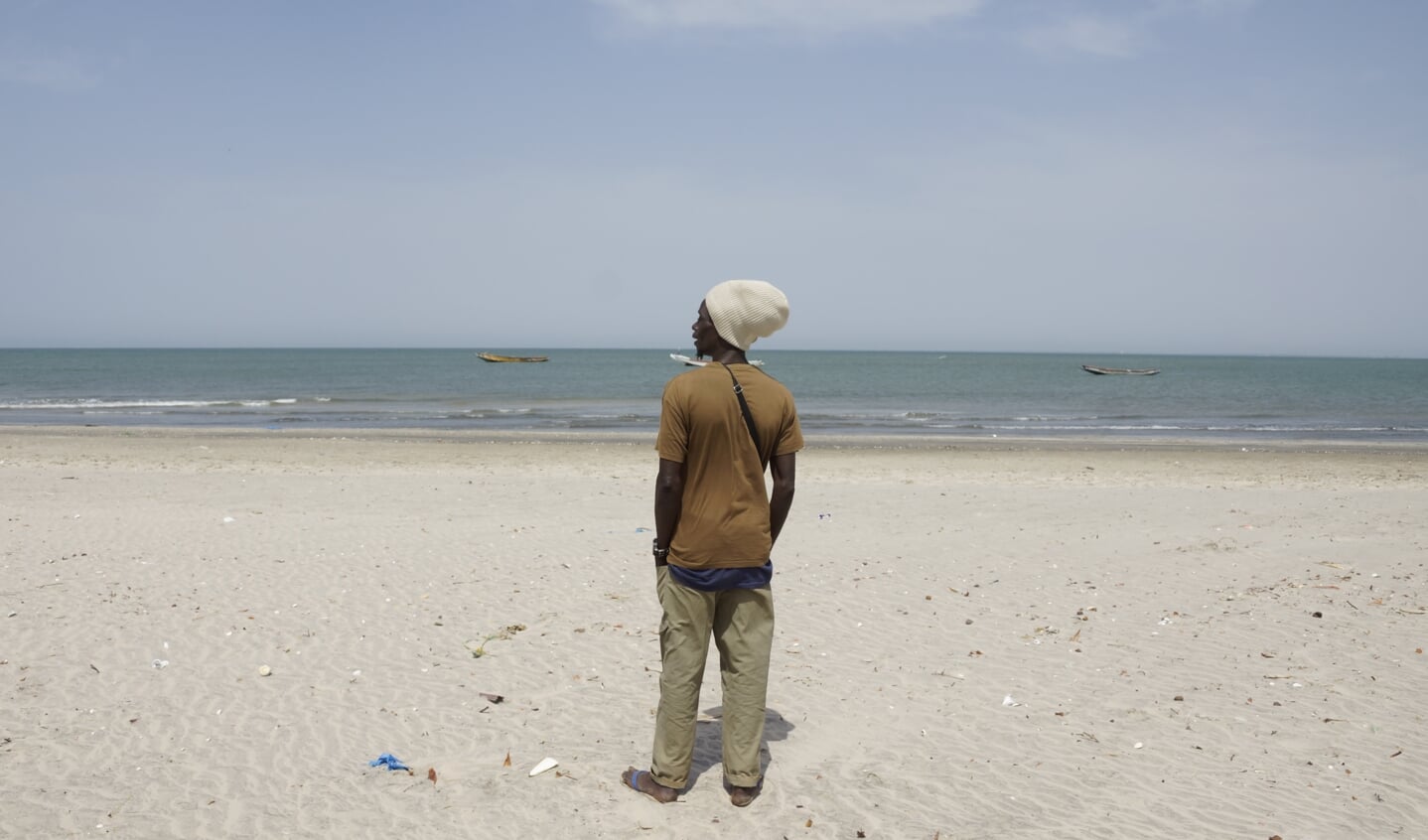 Een potentiële migrant op het strand van Bakau in Gambia. Vanaf de Gambiaanse kust is het hemelsbreed 1700 kilometer naar Gran Canaria.