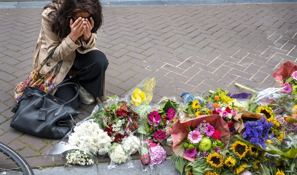Mensen laten bloemen, kaarsjes en steunbetuigingen aan Peter R. de Vries achter in de Lange Leidsedwarsstraat in het centrum van Amsterdam. (beeld anp / Evert Elzinga)