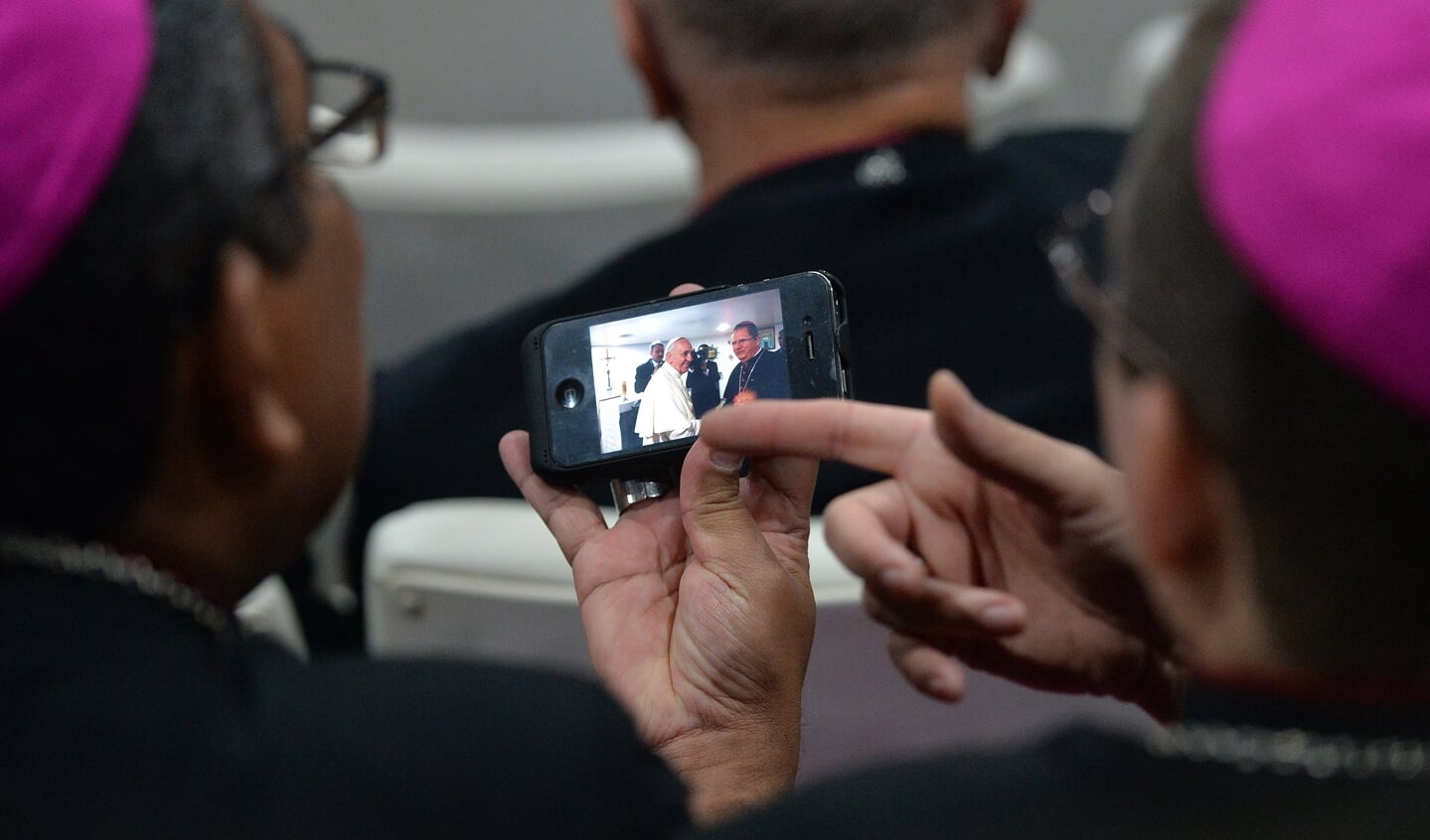 Bisschoppen in Rio de Janeiro bekijken een foto op een mobiele telefoon.