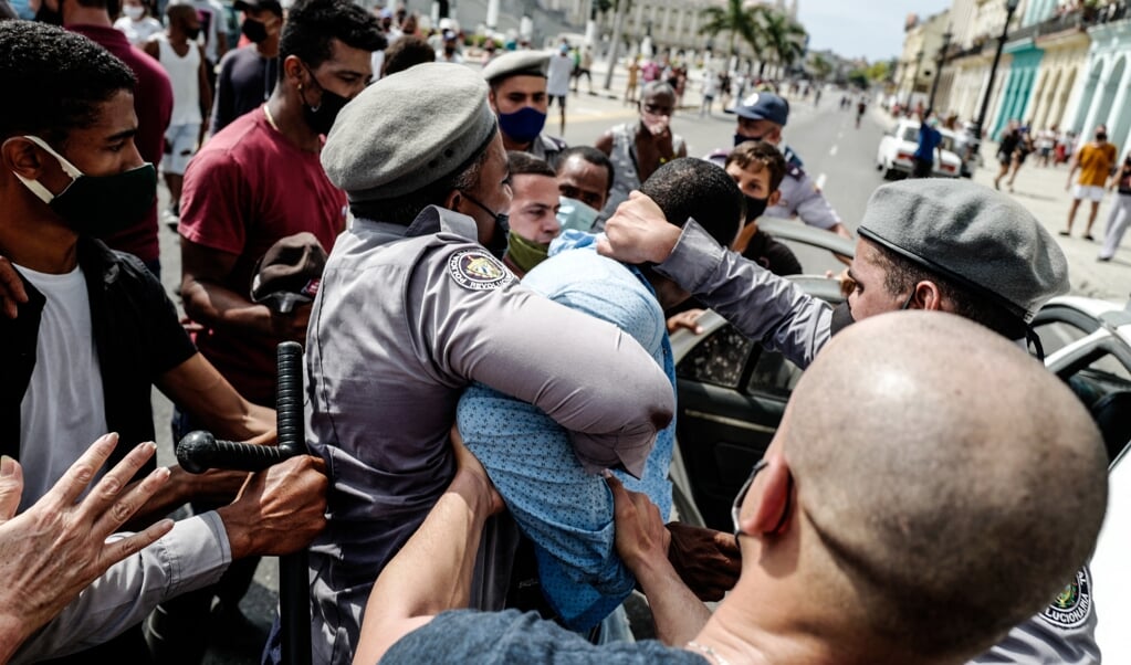Een man wordt gearresteerd in de Cubaanse hoofdstad Havana, tijdens een historisch volksprotest. (beeld afp / Adalberto Roque)