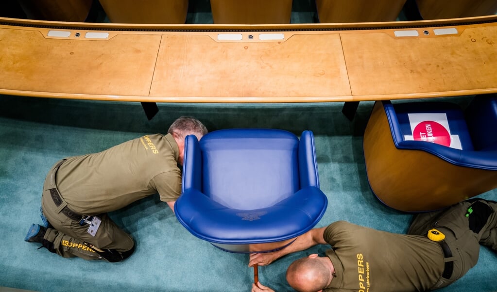 De blauwe Kamerzetels worden gedemonteerd en naar het tijdelijke onderkomen verplaatst. (beeld anp / Bart Maat)