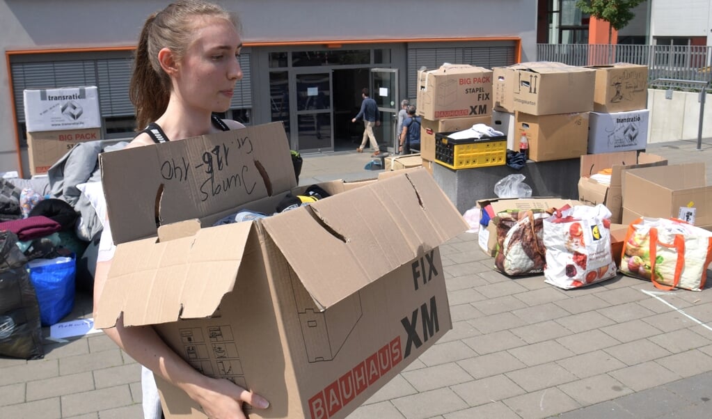 Scholieren helpen als vrijwilliger bij het Ville Gymnasium school in Erftstadt. (beeld afp / Sebastien Bozon)