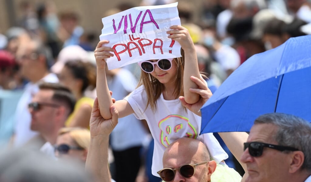 Een kind houdt op het Sint-Pietersplein in Rome een papier omhoog met de tekst 'Leve de paus!' terwijl paus Franciscus na het Angelusgebed op zondag 4 juli zijn pastorale bezoek aan Slowakije en zijn aanwezigheid in Boedapest aankondigt.   (beeld afp / Andreas Solaro)