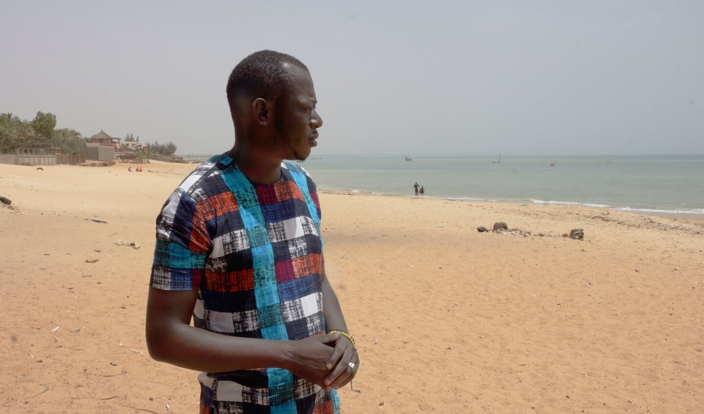 Mohamed Diop op het strand van Saly, Senegal. Vanaf deze plek deed hij twee pogingen om de Canarische Eilanden te bereiken. De tweede keer overleefde hij een schipbreuk. Ten minste23 opvarenden kwamen om het leven. Toch wil Mohamed het opnieuw proberen.