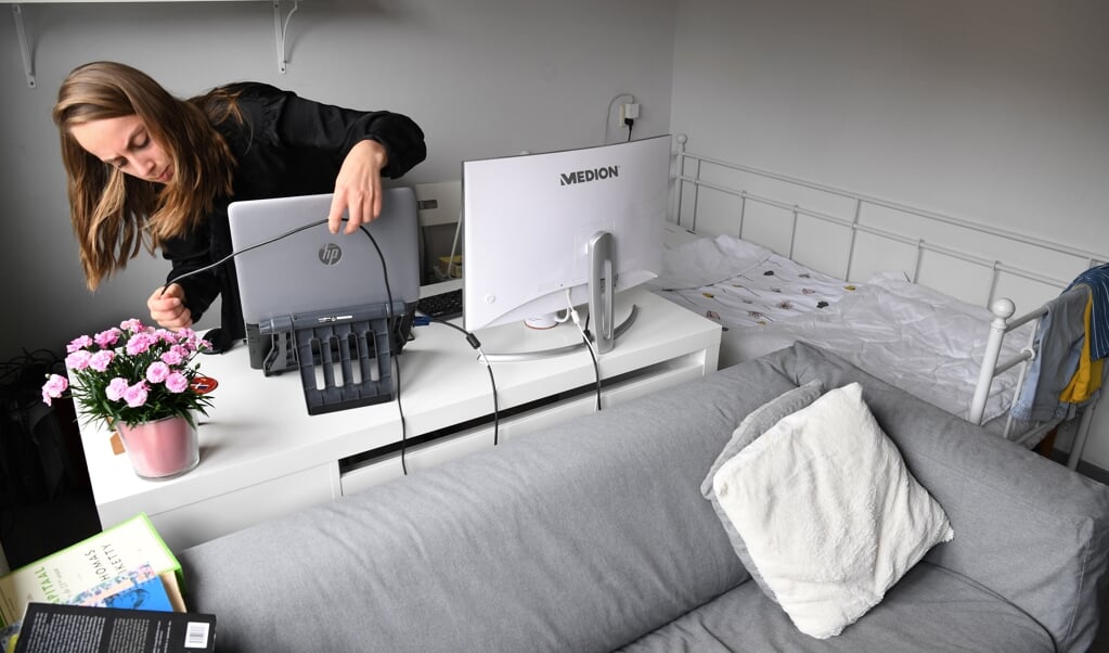 Leonie Schenkel plugt de laptop in in haar ‘kantoor’ van dertien vierkante meter. (beeld Marcel van den Bergh)