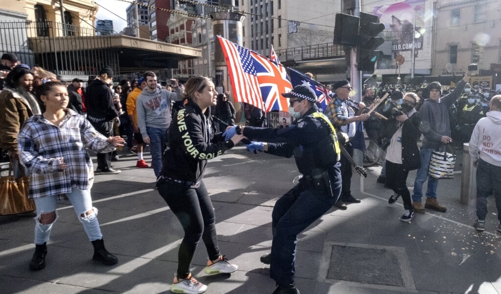 Australische demonstranten en politie raken slaags tijdens een anti-lockdownprotest zaterdag. (beeld epa / Luis Ascui)