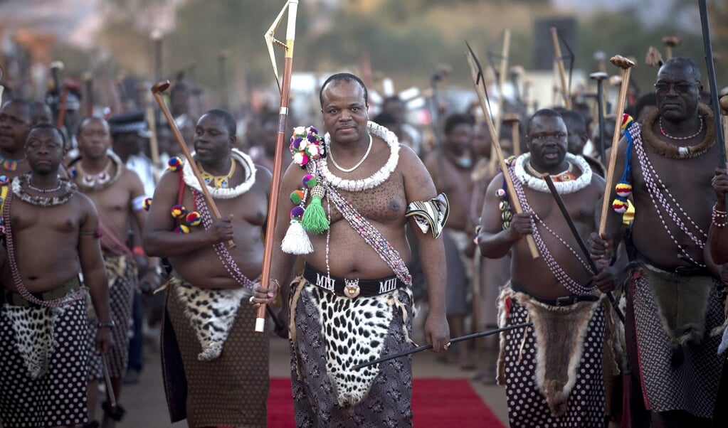 Koning Mswati III (midden) staat bekend om zijn vele vrouwen. Elk jaar kan hij - als het hem behaagt - een nieuwe vrouw uitkiezen tijdens de jaarlijkse Riet Dans, waarbij honderden halfnaakte jonge vrouwen voor hem dansen.  (beeld epa / Shiraaz Mohamed)