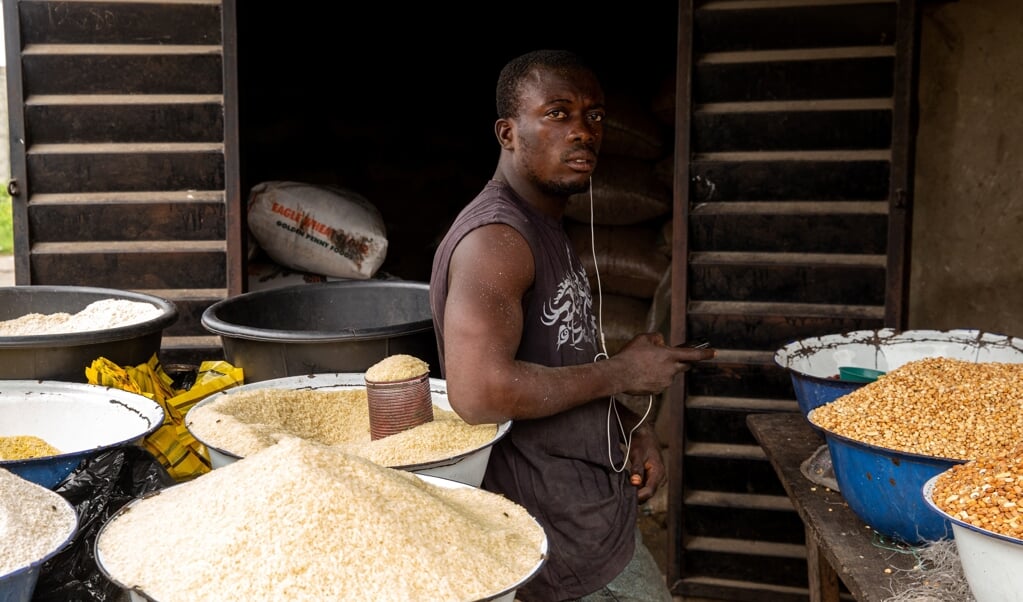 Een Nigeriaan poseert in zijn rijstwinkel in Badagry, bij Lagos, september 2019. 'Toch kiest Verre Naasten ervoor om zelfbewuste, krachtige broers en zussen uit bijvoorbeeld Afrika en Azië te portretteren.' (beeld afp / Benson Ibeabuchi)