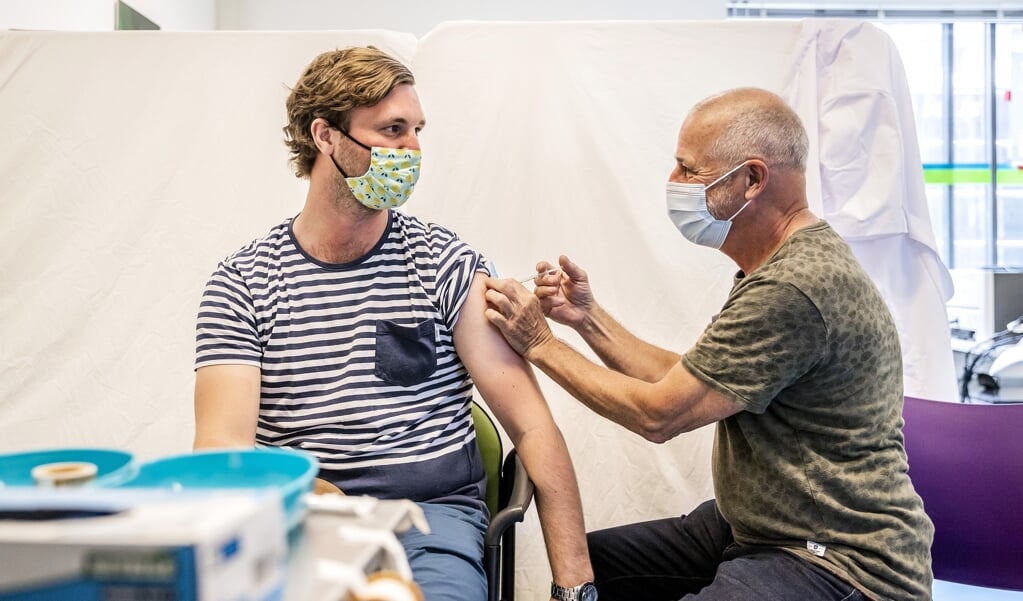 Een bewoner uit een Haagse wijk laat zich vaccineren in een gezondheidscentrum. (beeld anp / Remko de Waal)