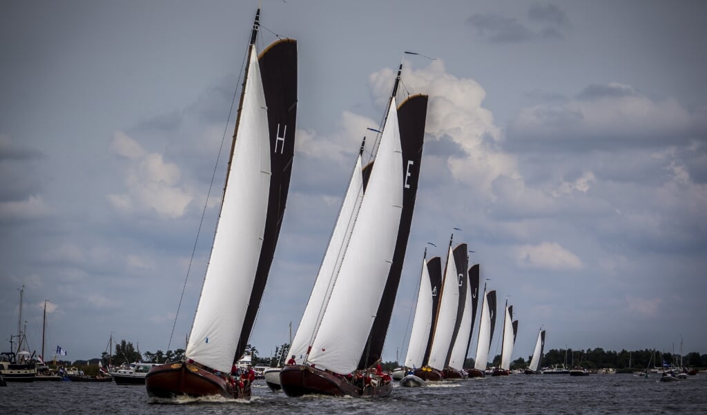 Skûtsjes in actie op het water bij Grou tijdens de eerste wedstrijd van het traditionele skûtsjesilen. (beeld anp / Siese Veenstra)