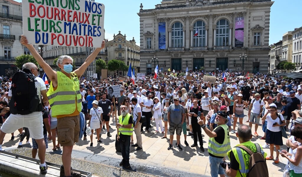 'Laten we onze beulen en hun machthebbers aan de kant zetten', staat er op dit bord, een leus uit de Franse revolutie. Het protest in Montpellier is tegen verplichte vaccinatie voor bepaalde werknemers en de verplichte gezondheidspas. (beeld afp / Pascal Guyot)