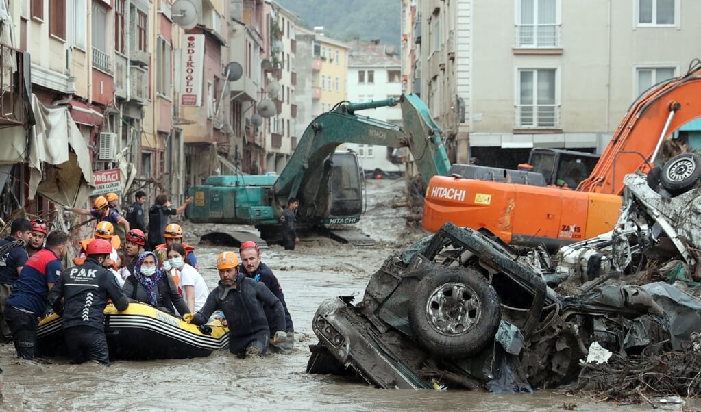Reddingswerkers in de Turkse provinciehoofdstad Kastamonu brengen burgers in veiligheid die door het water overvallen zijn. (beeld epa / Mehmet Kaman)