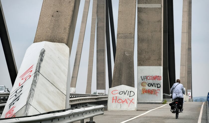 Op de brug van de snelweg A50 bij Echteld hebben virusontkenners hun leuzen gekalkt.
