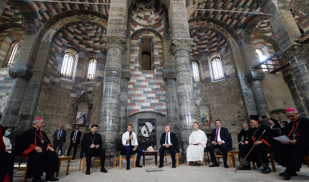 De Franse president Macron (midden links) in kerk van de dominicanen in Mosul, de Notre-Dame de l’Heure. Deze kerk werd vier jaar geleden door ISIS verwoest en is hersteld met financiële steun van de Verenigde Naties. (beeld afp / Zaid Al-obeidi)