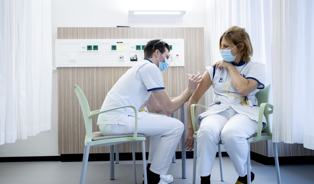 Een verpleegkundige krijgt een vaccinatie in het HMC.  (beeld anp / Koen van Weel)
