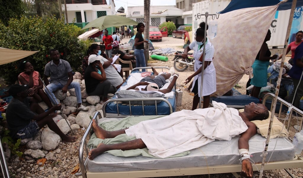 Slachtoffers in de stad Les Cayes, voor wie geen plek meer in het ziekenhuis is.  (beeld epa / Orlando Barrã­a)