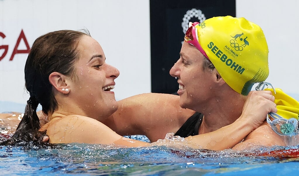 Een overwinning die wordt gedeeld: de Australische zwemster Kaylee McKeown (l.) krijgt de felicitaties van haar teammaat Emily Seebohm na het winnen van de honderd meter rugslag op de Olympische Spelen in Tokio, die zondag werden afgesloten. (beeld epa / Valdrin Xhemaj)