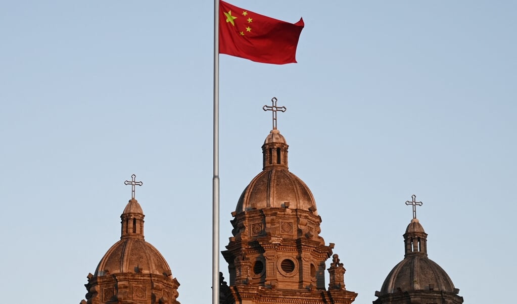 De Chinese vlag voor de Sint Jozefkerk in Beijing. Ondanks repressies groeit het (protestants) christendom in China. (beeld afp / Greg Baker)