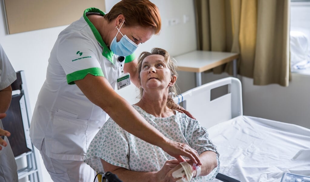 Verpleegkundige Carola Veer controleert een niet-gevaccineerde patiënt die kortgeleden van de intensive care is gekomen. (beeld Arie Kievit)