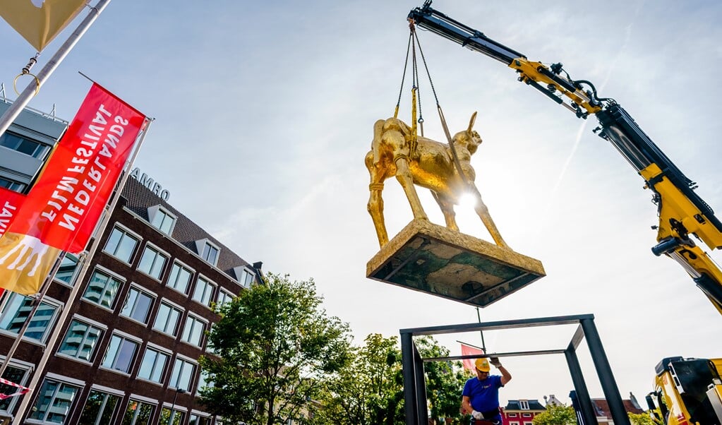 Op de Neude in Utrecht wordt het icoon van het Nederlands Film Festival geplaatst, een groot Gouden Kalf. De gelijknamige filmprijzen worden aan het eind van het festival uitgereikt. (beeld anp / Marco de Swart)