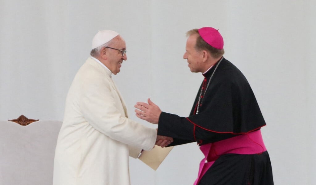 De Litouwse aartsbisschop Gintaras Linas Grusas schudt op 22 september 2018 de hand van paus Franciscus tijdens diens bezoek aan de Litouwse hoofdstad Vilnius. (beeld afp / Petras Malukas)