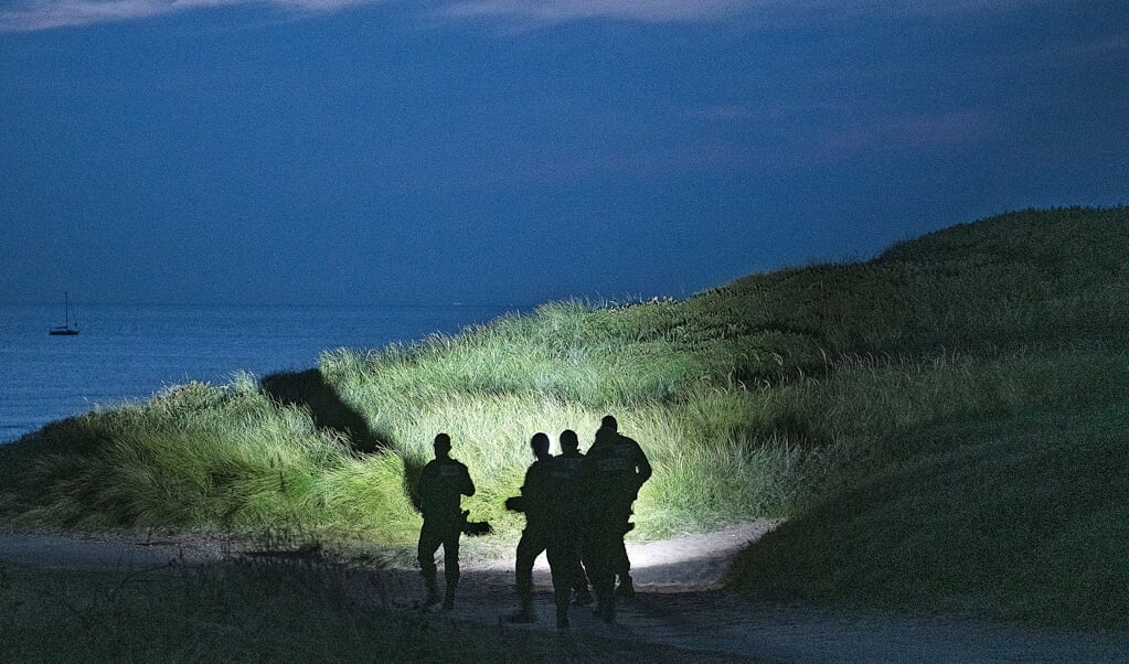 De Franse politie inspecteert de duinen bij Wimereux, waar het Kanaal op z’n smalst is. Veel vluchtelingen gaan via dit plaatsje naar Engeland met een bootje. (beeld Guus Dubbelman)