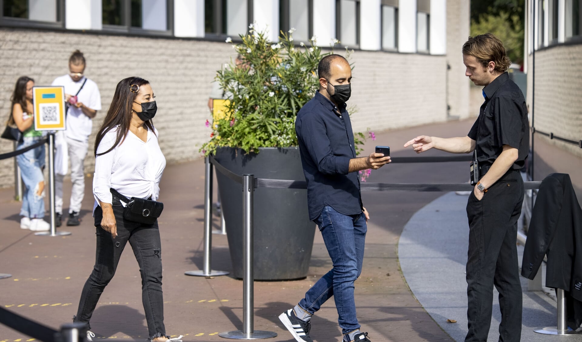 Bezoekers bij het Van Gogh museum met hun mobiele telefoon voor de ingang.