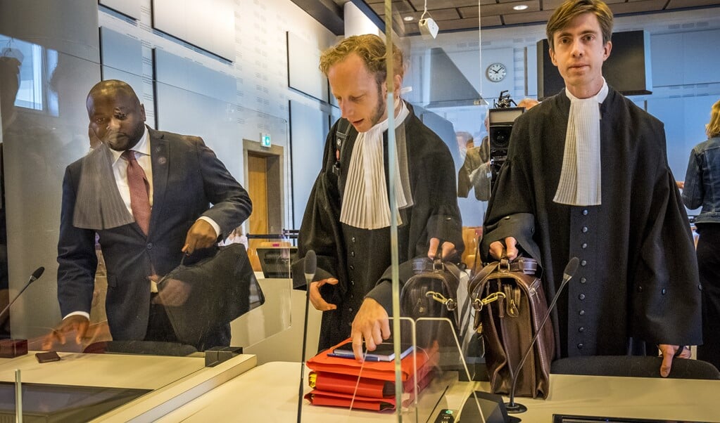 Advocaat Jelle Klaas (midden) samen met Mpanzu Bamenga (links) voorafgaand aan de uitspraak van de rechtbank. (beeld anp / Lex van Lieshout)