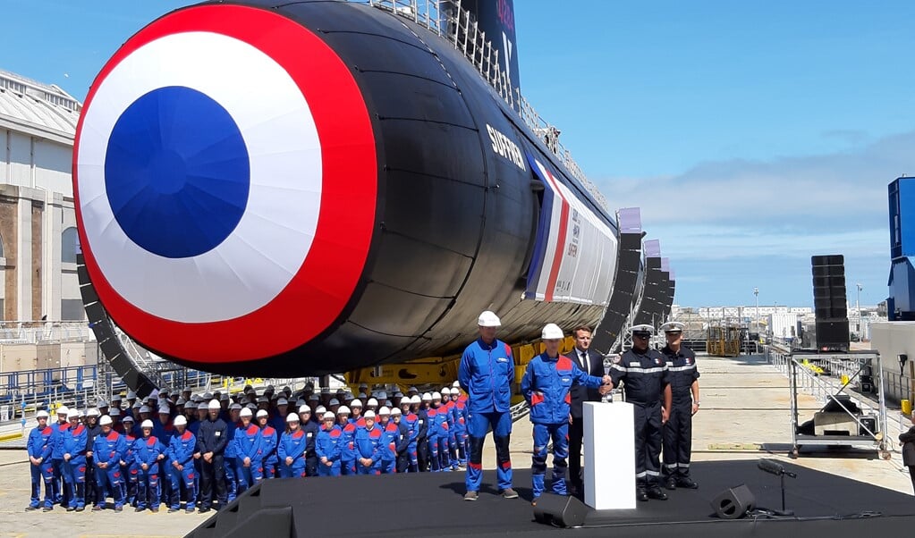 De Franse president Macron (midden achter katheder) op de werf van Naval Group bij de presentatie van de nucleaire onderzeeboot Suffren. (beeld )