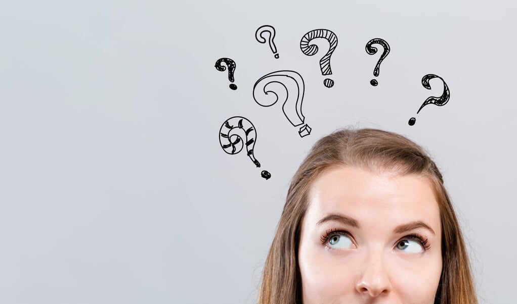 Hand draw question marks with young woman looking upwards on a gray background  (beeld istock)