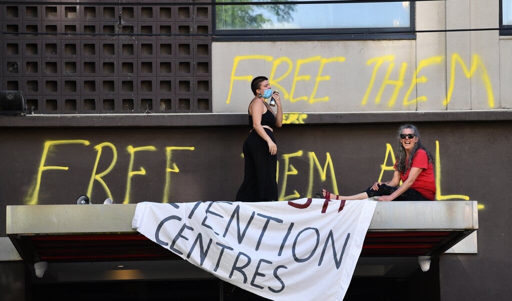Fans protesteren buiten het Australische detentiehotel waar Djokovic verblijft tegen diens behandeling. (beeld epa / James Ross)
