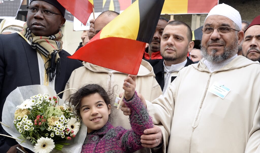 Imam Mohamed Toujgani (rechts) nam in 2016 deel aan een eerbetoon aan de slachtoffers van de terreuraanslagen in Brussel.  (beeld afp / Thierry Charlier)