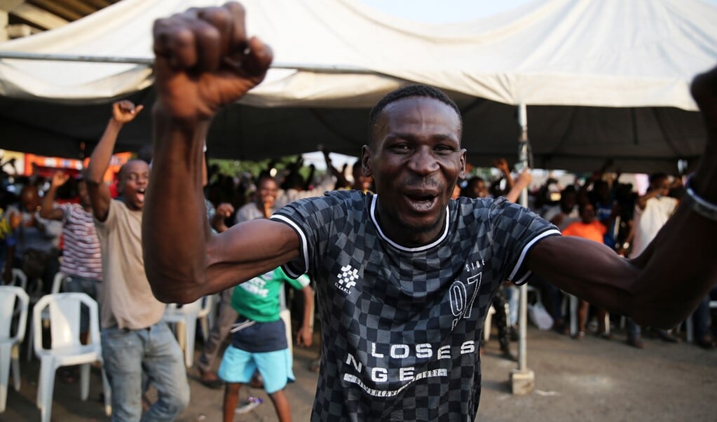 Een Nigeriaanse voetbalfan juicht nadat zijn land heeft gescoord in het duel met Egypte.  (beeld epa / Akintunde Akinleye)