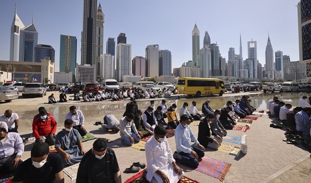 Op de eerste vrijdag van het nieuwe jaar zochten moslims in Dubai een plek vlak bij hun werk om het vrijdaggebed te verrichten.  (beeld afp / Karim Sahib)