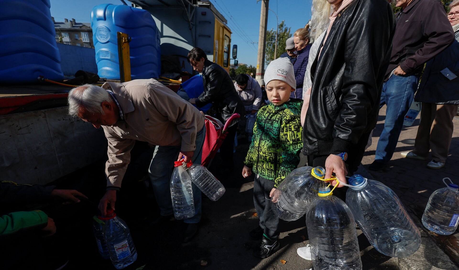 Inwoners van Mykolajiv in de regio Cherson vullen maandag flessen met schoon drinkwater omdat de watertoevoer door de Russen is beschadigd.