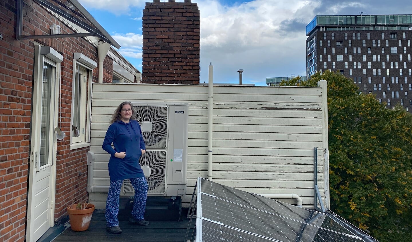 Musetta Blaauw bij de buitenunit van de warmtepomp van haar woning.