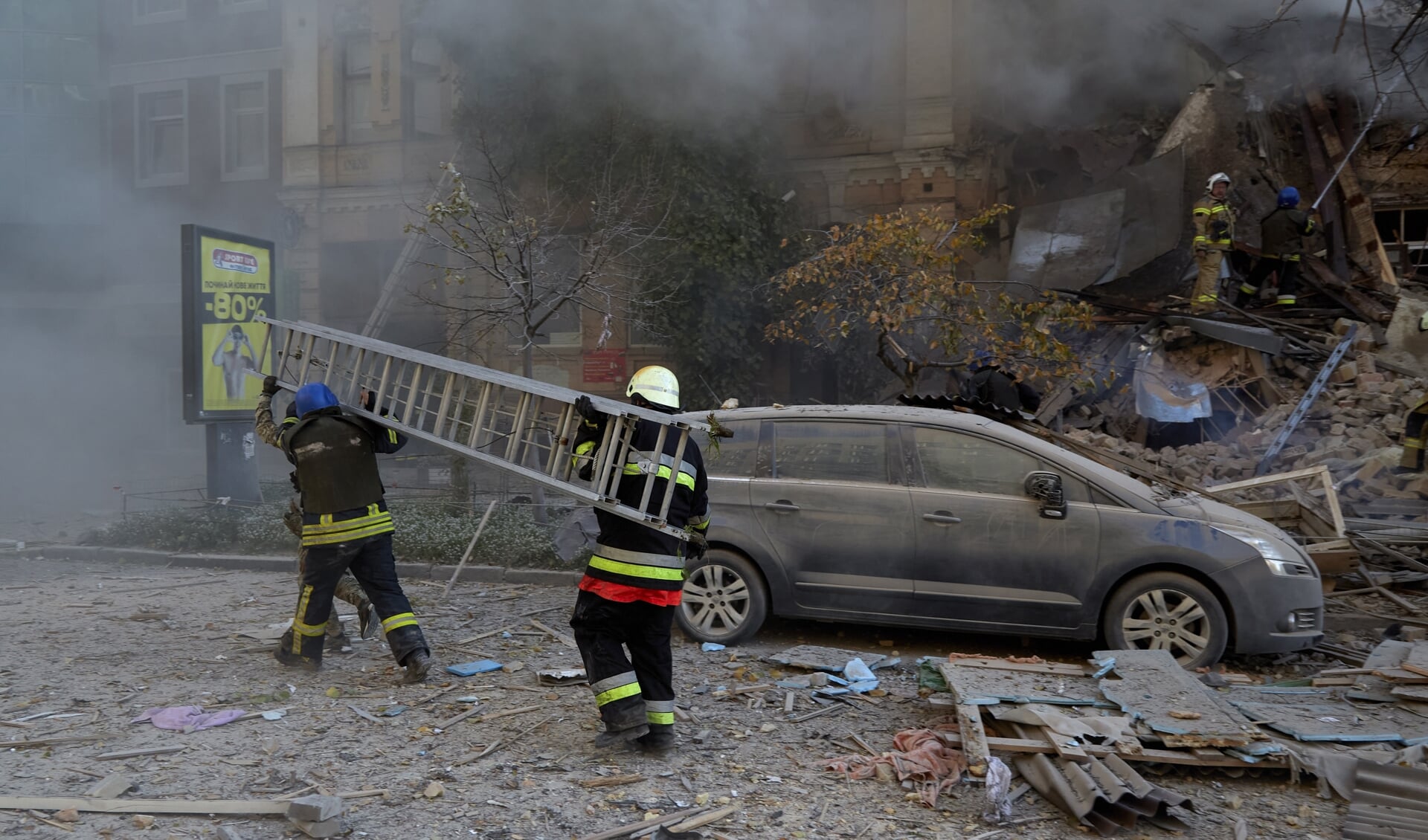 Brandweermannen in Kyiv lopen rond na de bombardementen door Russische drones.