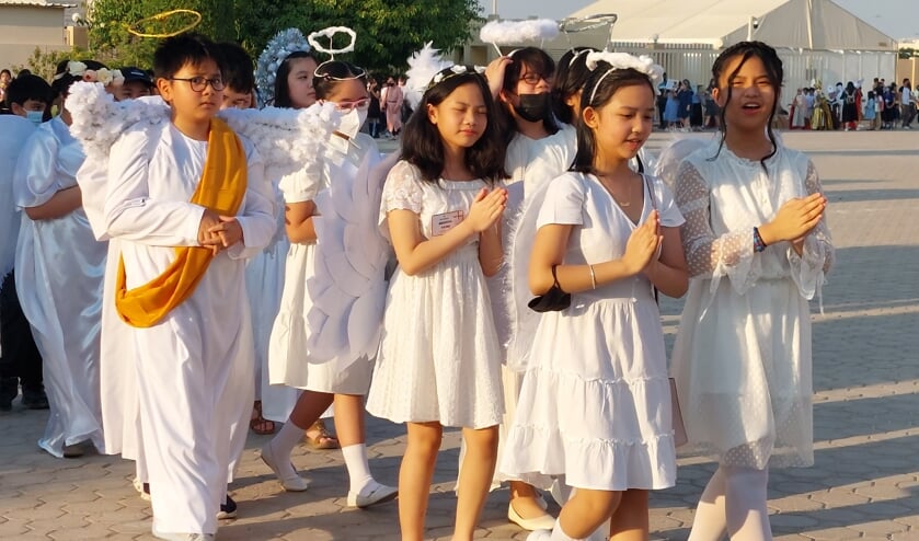 Filipijnse tieners lopen in een katholieke processie in Doha, binnen de muren van het Religieus Complex'