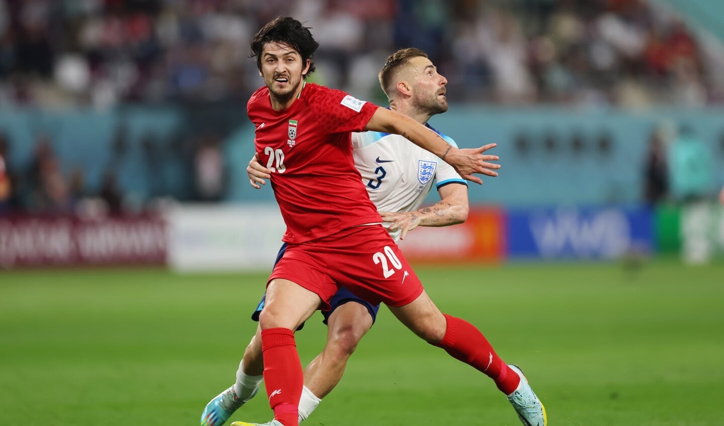 Aanvaller Sardar Azmoun uit Iran (links) tegen de Engelse Luke Shaw tijdens de wedstrijd tussen England-Iran.
