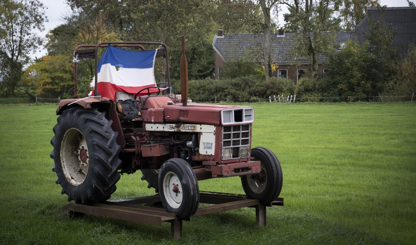 In een weiland staat een tractor vast opgesteld waaraan een Nederlandse vlag omgekeerd wappert als protest tegen alle maatregelen tegen boeren.
ANP / Hollandse Hoogte / Anjo de Haan