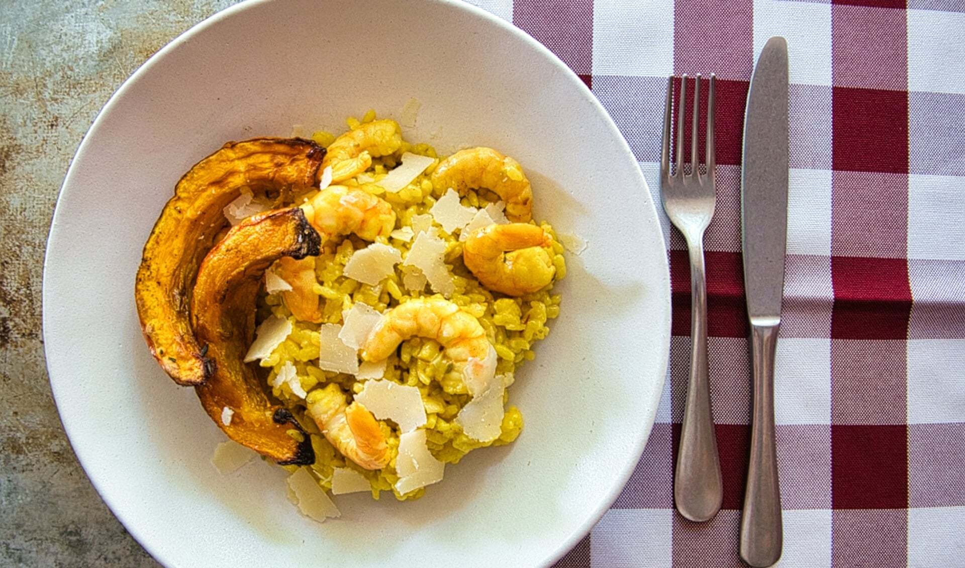 Saffraanrisotto met gegrilde pompoen en garnalen.