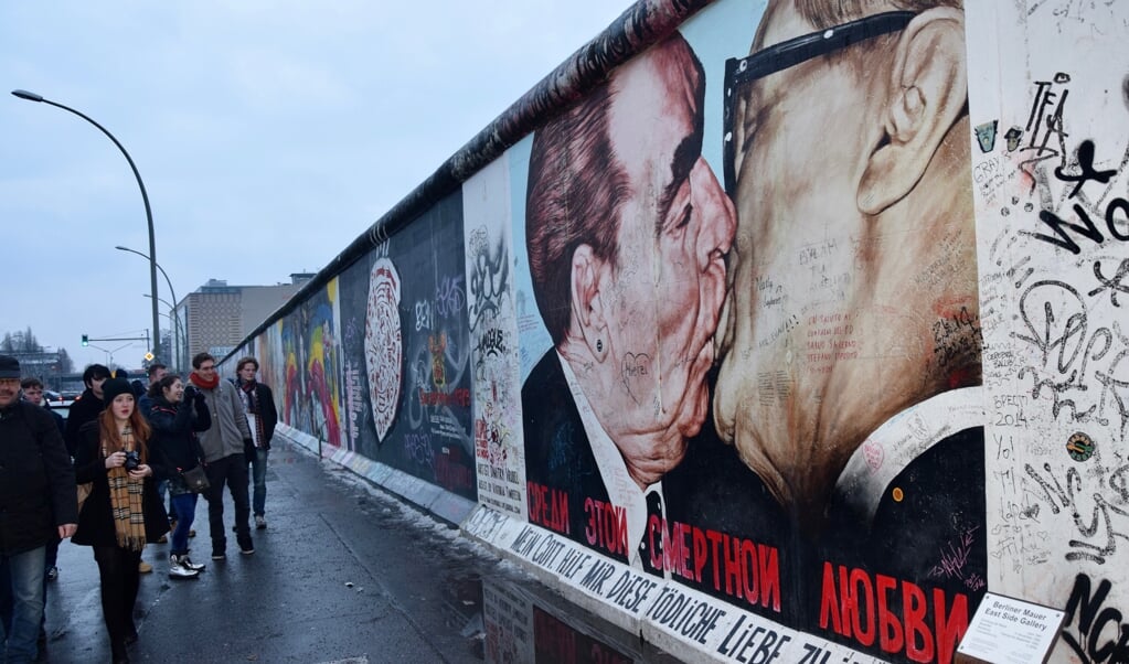 Sovjetleider Brezjnjev omhelst de Oost-Duitse leider Honecker (r), tekening op de Berlijnse Muur. Het Kremlin kan het verlies van Oost-Europa niet vergeten.  (beeld wikimedia)