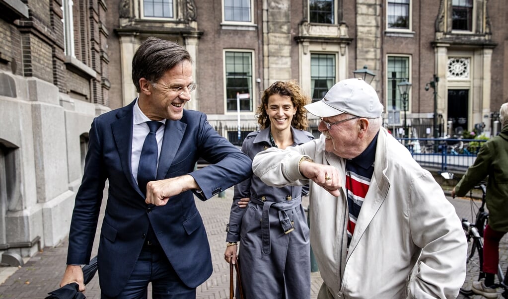 Mark Rutte geeft een elleboogje aan een voorbijganger.   (beeld anp / sem van der wal)