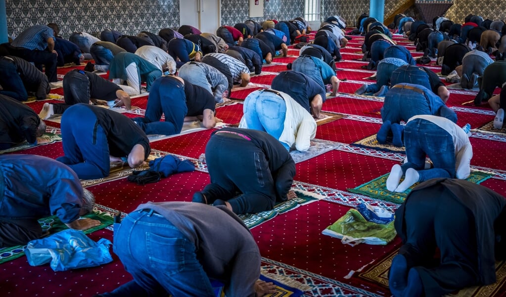 Moslims bidden in een moskee.  (beeld anp / lex van Lieshout)