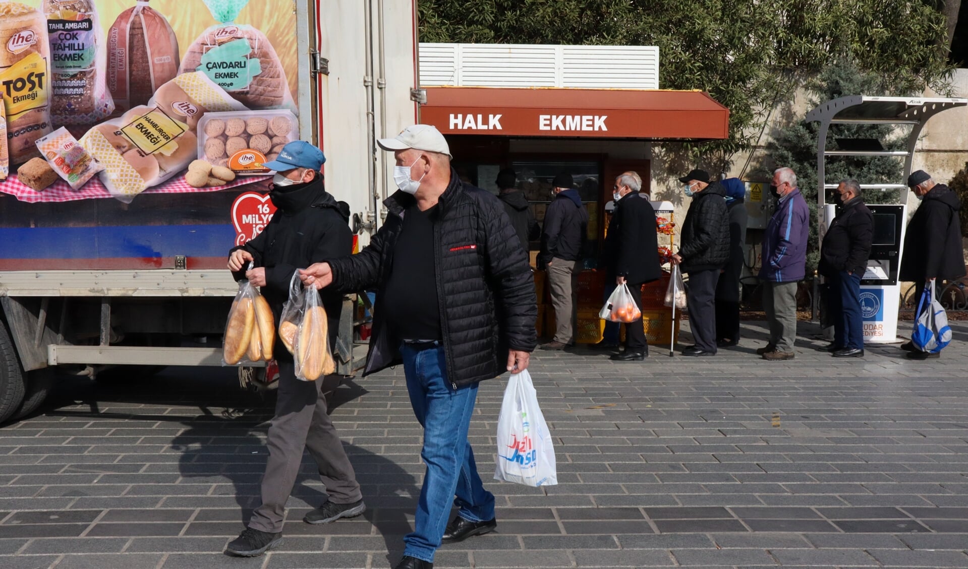 Twee mannen hebben brood gekocht bij de kiosk met goedkoop brood (Halk Ekmek) in de wijk Üsküdar in Istanbul.