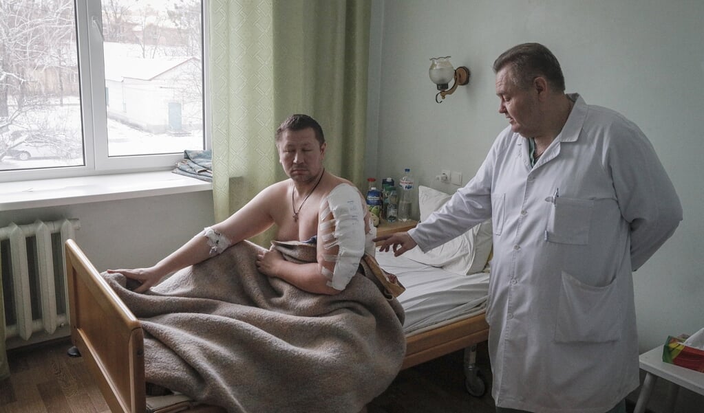 Een dokter in Brovary, dichtbij Kyiv, gaat langs bij een gewonde patiënt na de Russische inval.  (beeld Epa/sergey Dolzhenko)